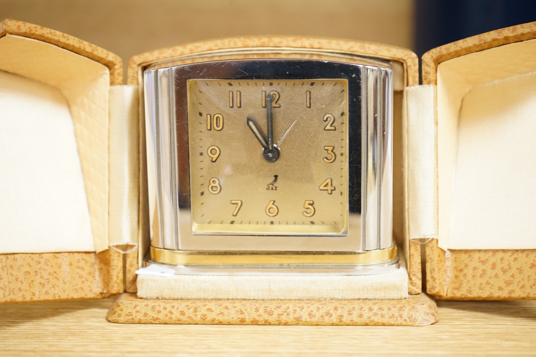 Two Art Deco timepieces comprising a Japy alarm clock and a Jas cased travelling example, largest 22cm wide